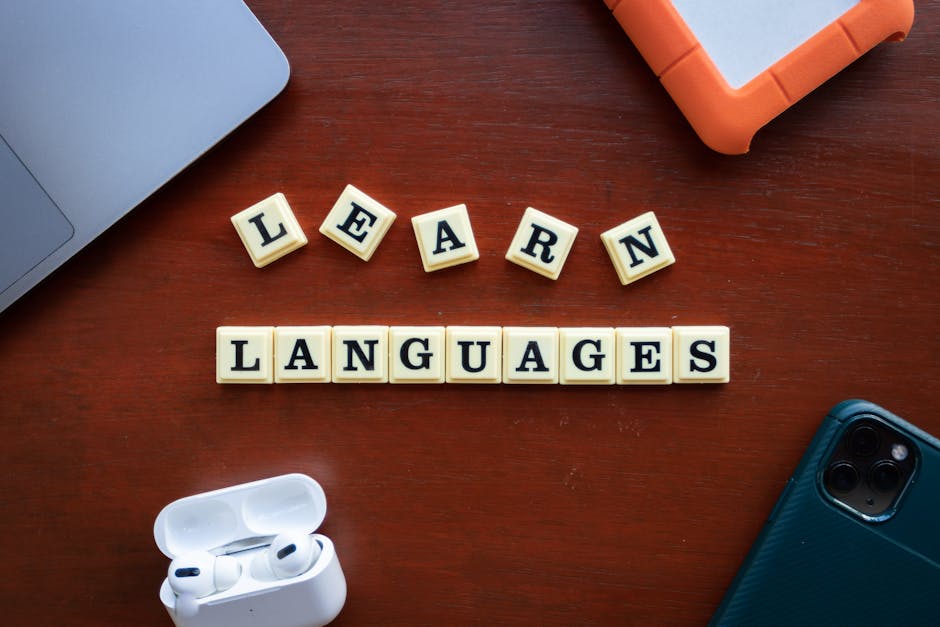 Scrabble-Steine bilden die Worte LEARN LANGUAGES auf einem Schreibtisch